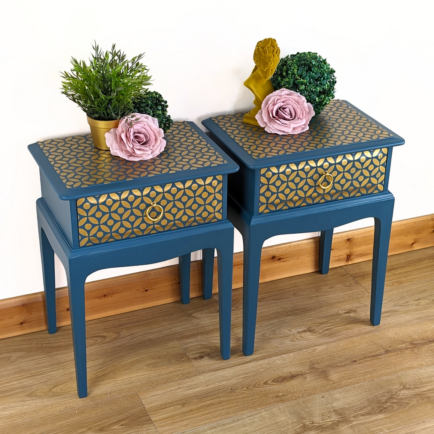Pair of Stag Minstrel bedside cabinets, 'leggy' mid-century design with single drawers, painted in a teal blue with gold stencil detailing