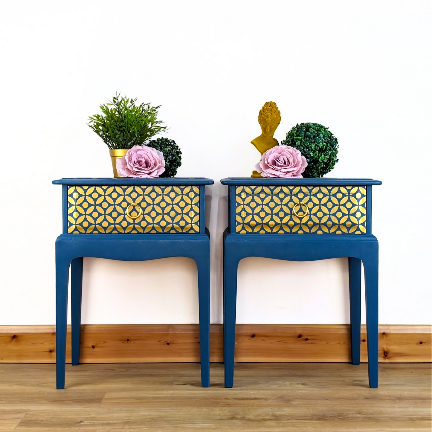 Pair of Stag Minstrel bedside cabinets, 'leggy' mid-century design with single drawers, painted in a teal blue with gold stencil detailing