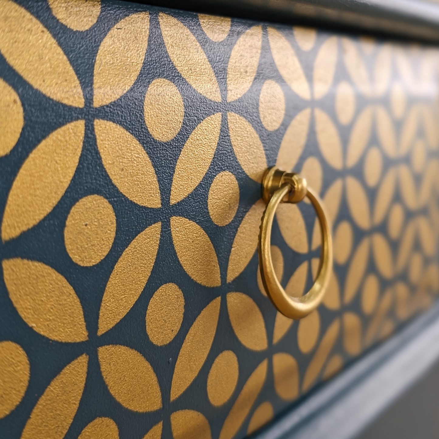 Pair of Stag Minstrel bedside cabinets, 'leggy' mid-century design with single drawers, painted in a teal blue with gold stencil detailing