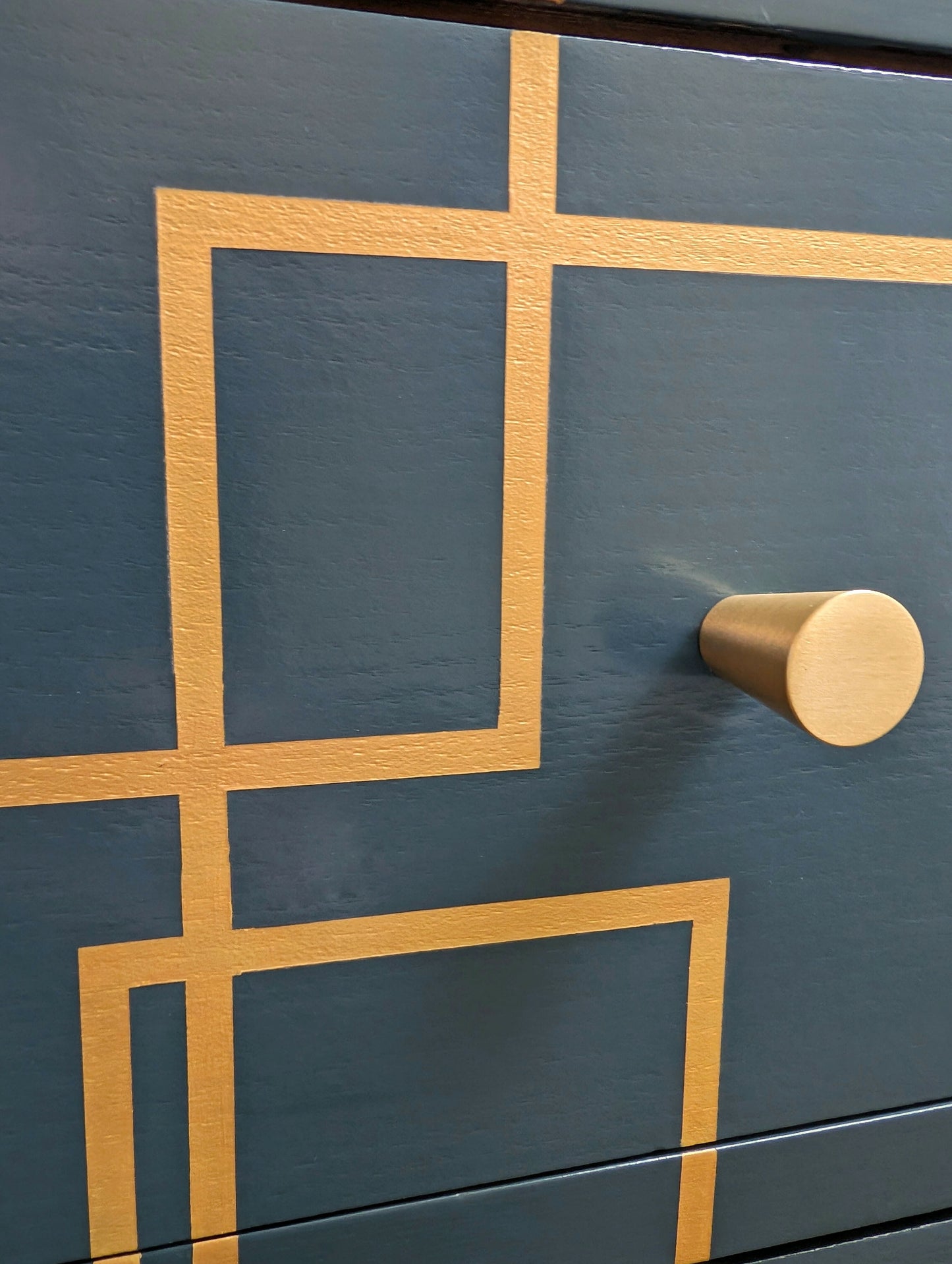 close up of blue and gold chest of drawers