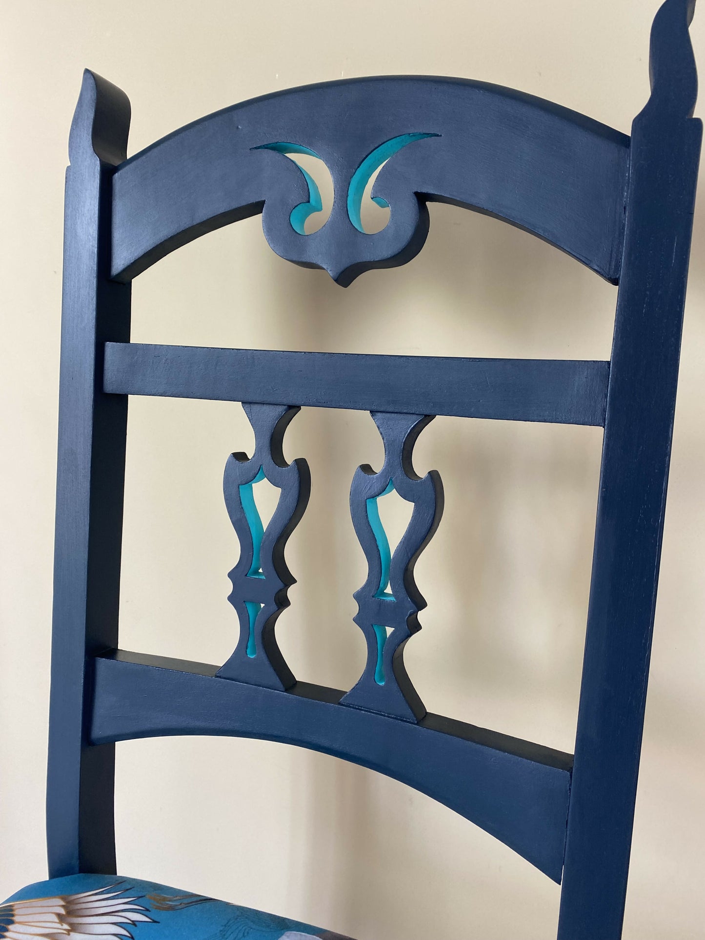 A blue painted high back vintage chair reupholstered in a turquoise blue crane and flower fabric