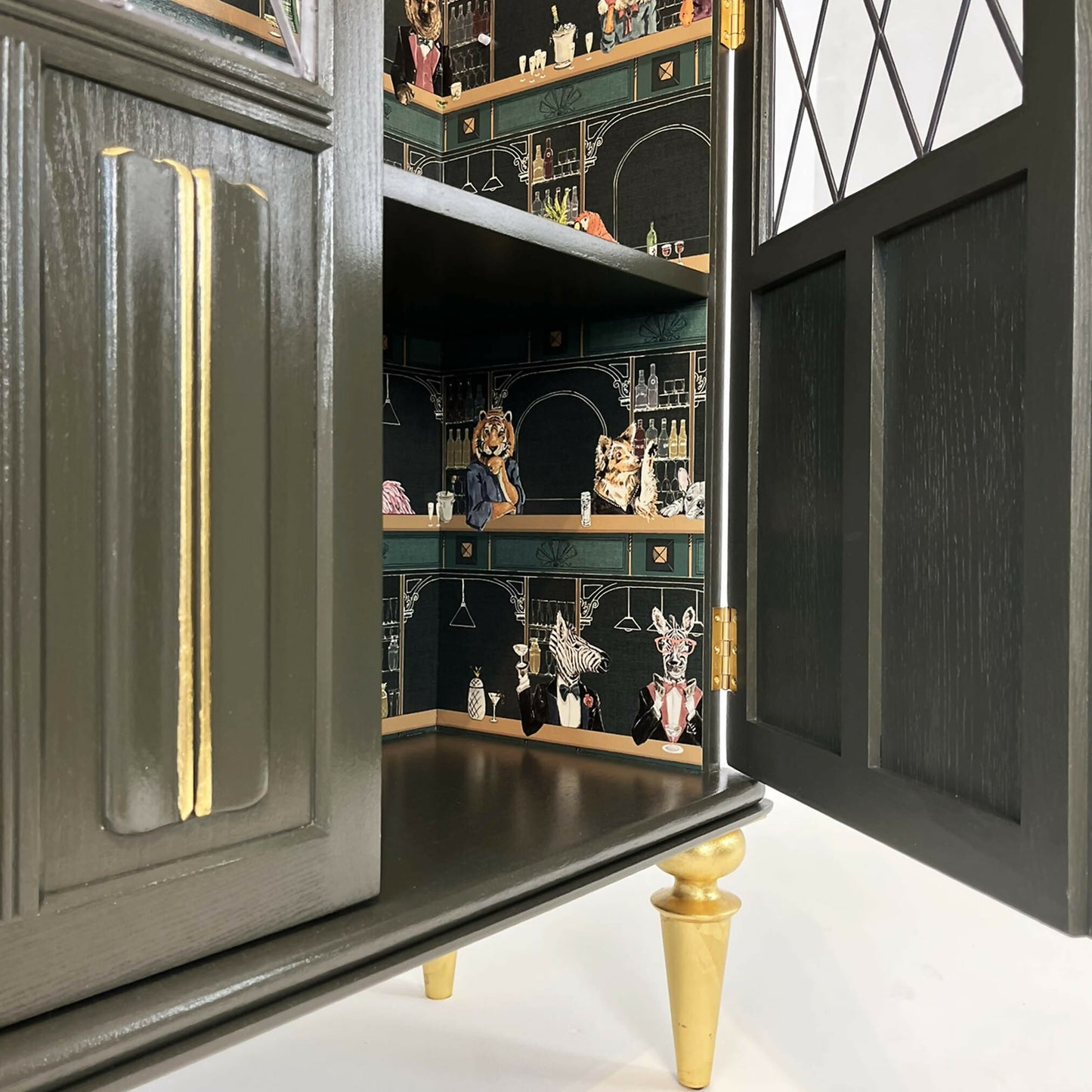 Antique style china cabinet with animals in the bar, painted green and gold guilded