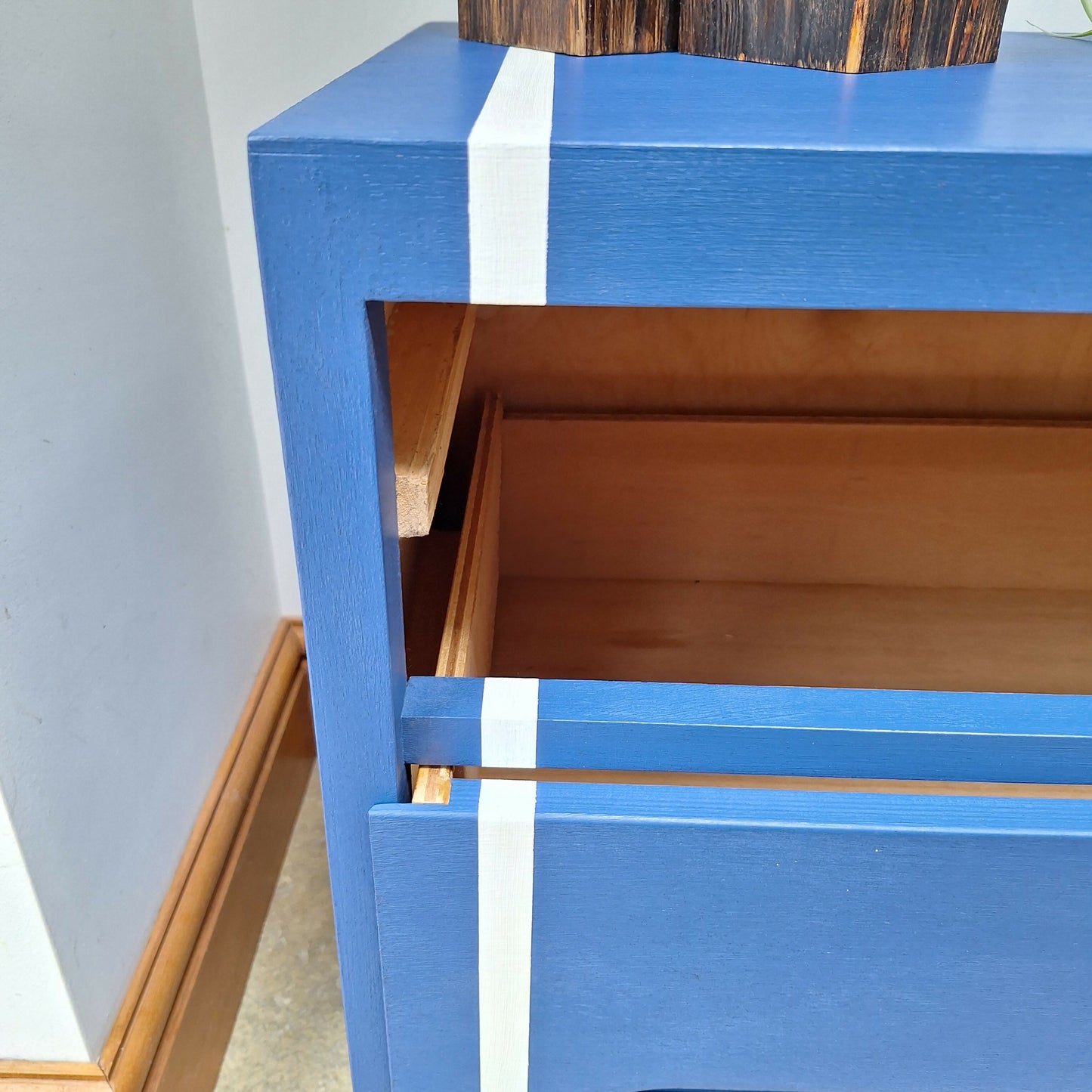 Small Simple Blue Chest Of Drawers With A White Stripe