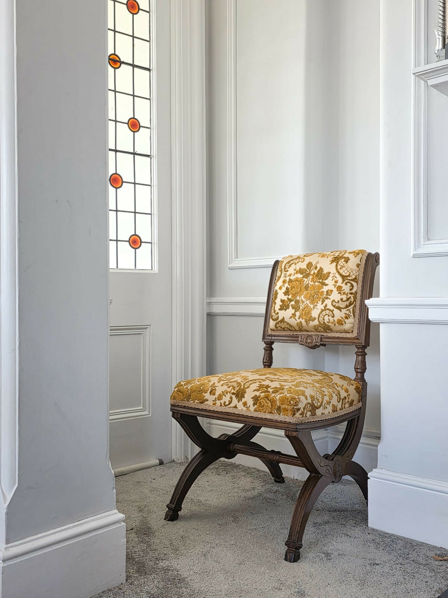 A late 19th-century Renaissance-style / aesthetic movement Curule chair featuring a walnut frame and ornate floral upholstery.