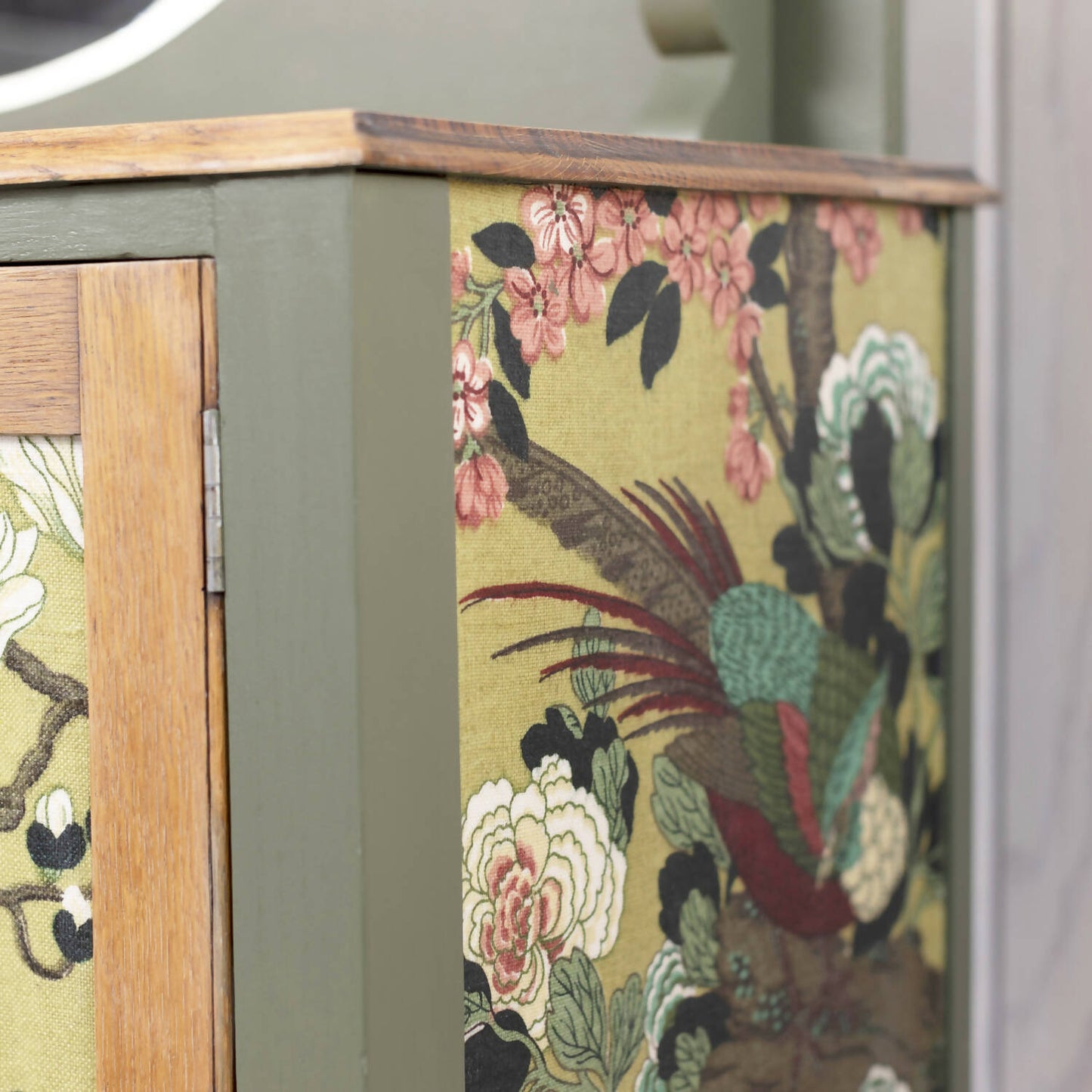 An exceptional vintage sideboard in a unique olive green hue, featuring an oval mirror and decoupaged in original Rockbird fabric. Sold: Commission Available.