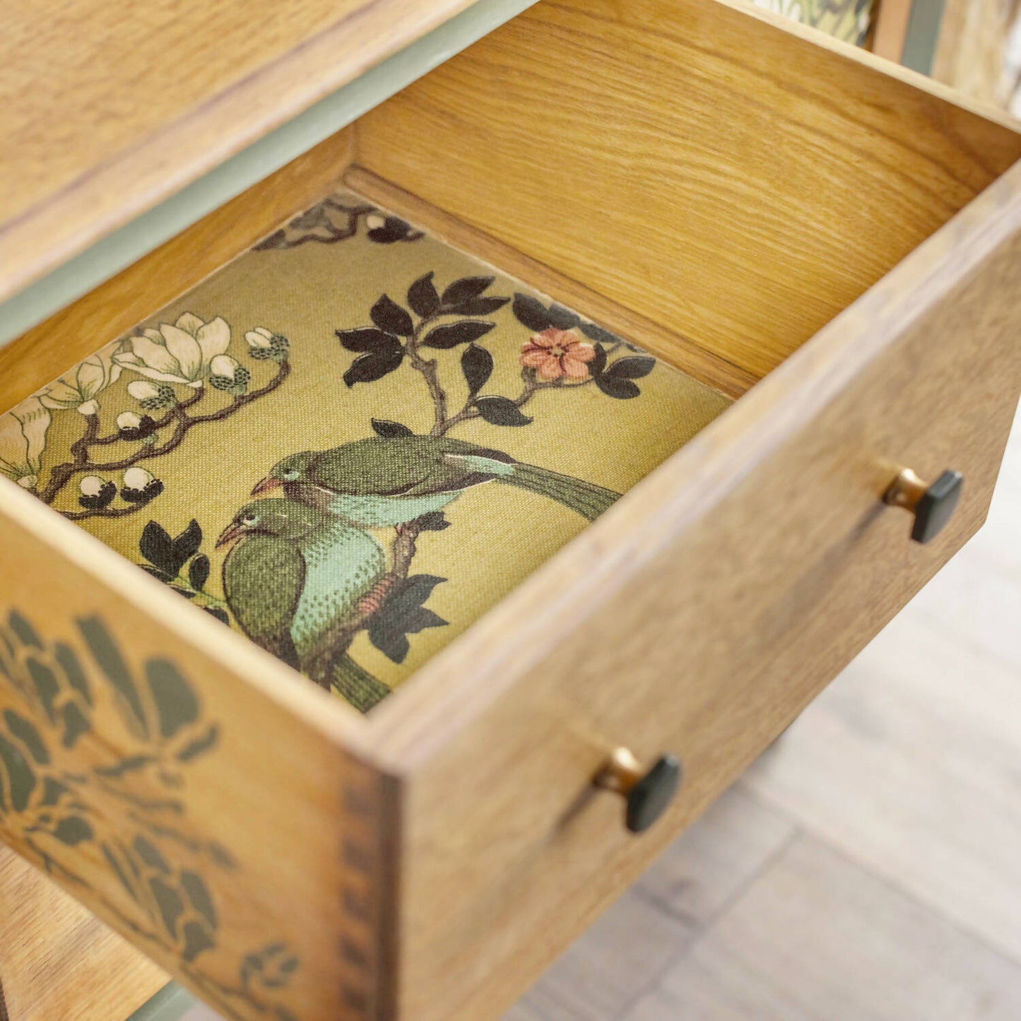 An exceptional vintage sideboard in a unique olive green hue, featuring an oval mirror and decoupaged in original Rockbird fabric. Sold: Commission Available.
