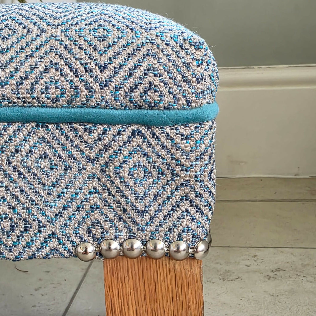 Long, Low Footstool, Restored and Reupholstered in Top Quality Woven Fabric.Teak wood feet. Newly Reupholstered.