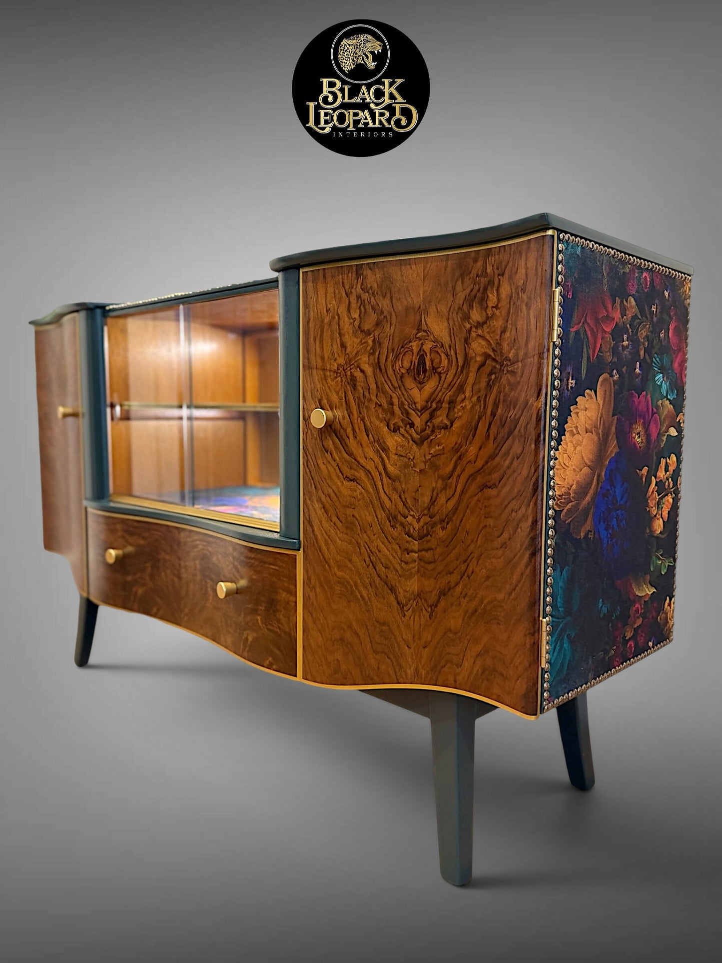 Professionally refinished vintage art deco sideboard with burr walnut, illuminated glass display and floral side panels by Black Leopard Interiors. Luxury bespoke furniture refinishing and restoration handcrafted handpainted UK