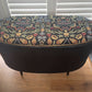 Black oval mid century modern ottoman - black paint William Morris style fabric