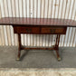 Antique drop-leaf Pembroke table with a leather top and brass claw feet.