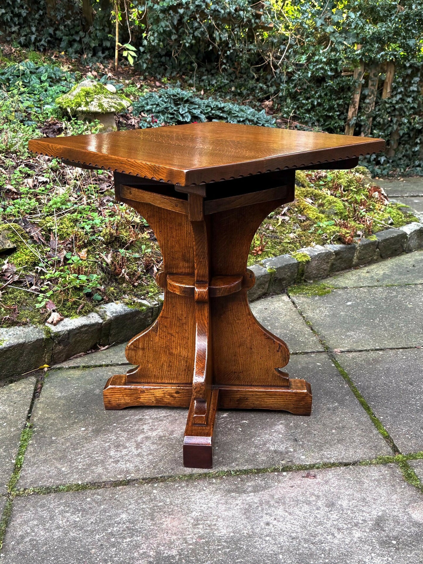 A RUPERT GRIFFITHS MONASTIC CARVED SOLID OAK LAMP TABLE / PLANT STAND