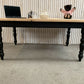 Pine dining table with a black base and a lacquered pine top.