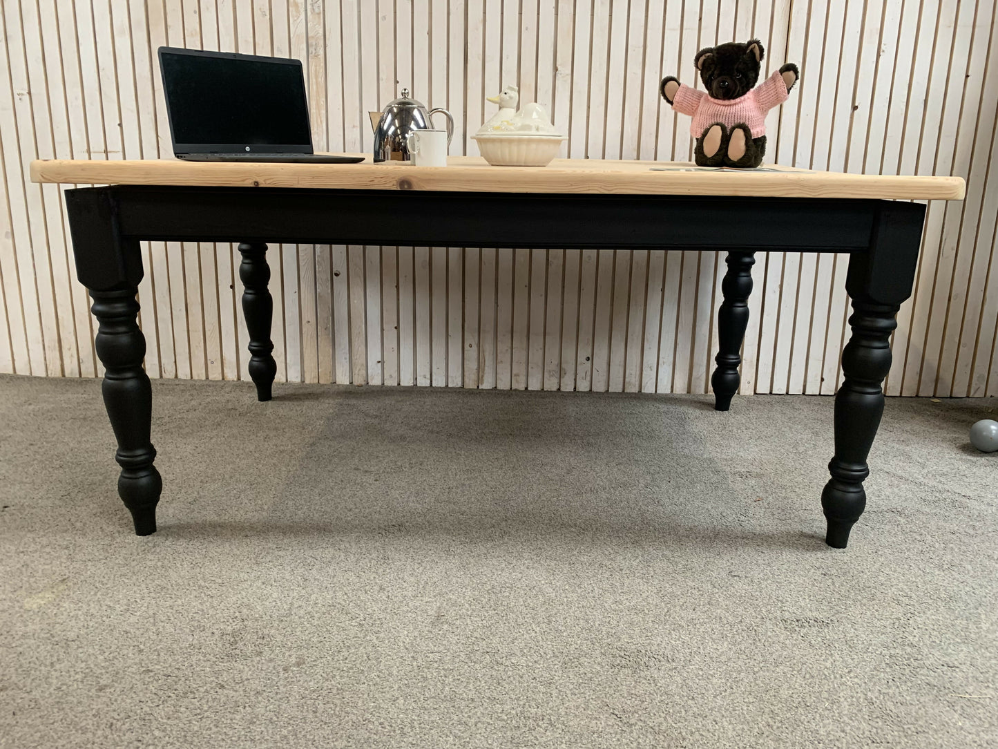 Pine dining table with a black base and a lacquered pine top.