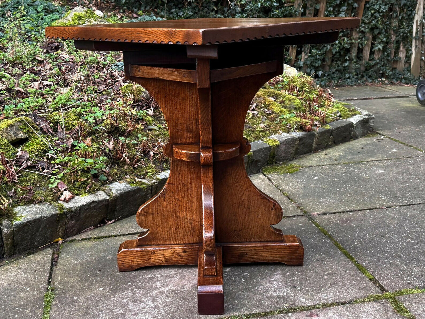 A RUPERT GRIFFITHS MONASTIC CARVED SOLID OAK LAMP TABLE / PLANT STAND