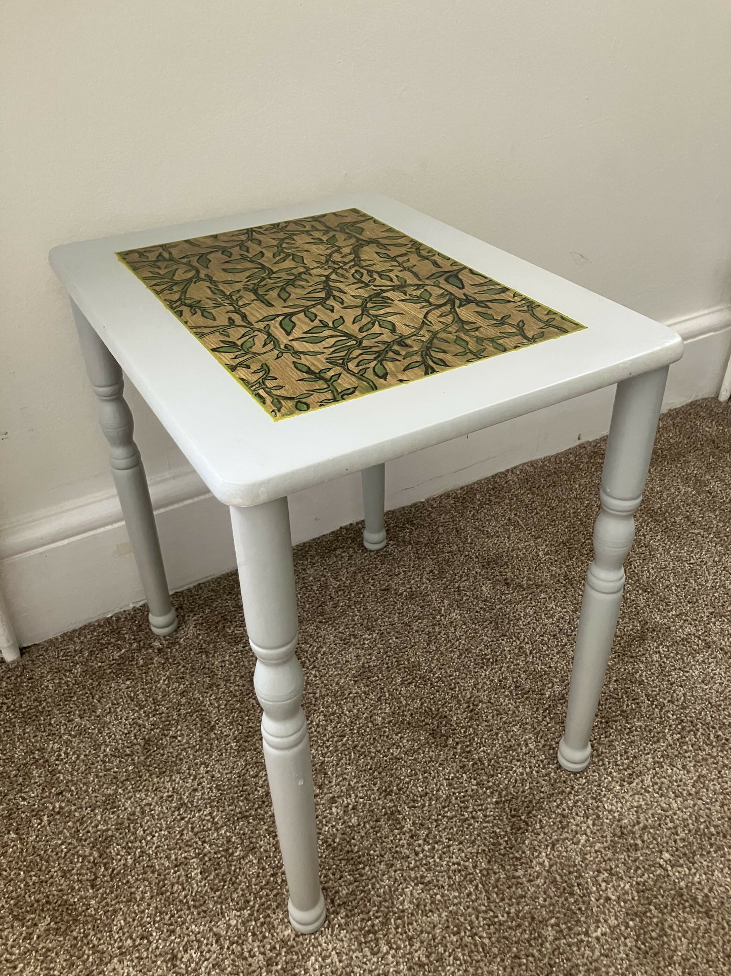 Light grey side table with hand-carved sage motif