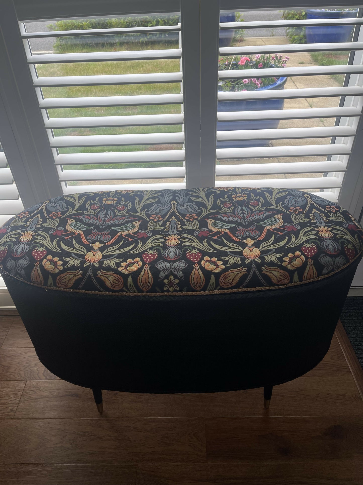 Black oval mid century modern ottoman - black paint William Morris style fabric