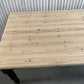 Pine dining table with a black base and a lacquered pine top.