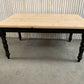Pine dining table with a black base and a lacquered pine top.