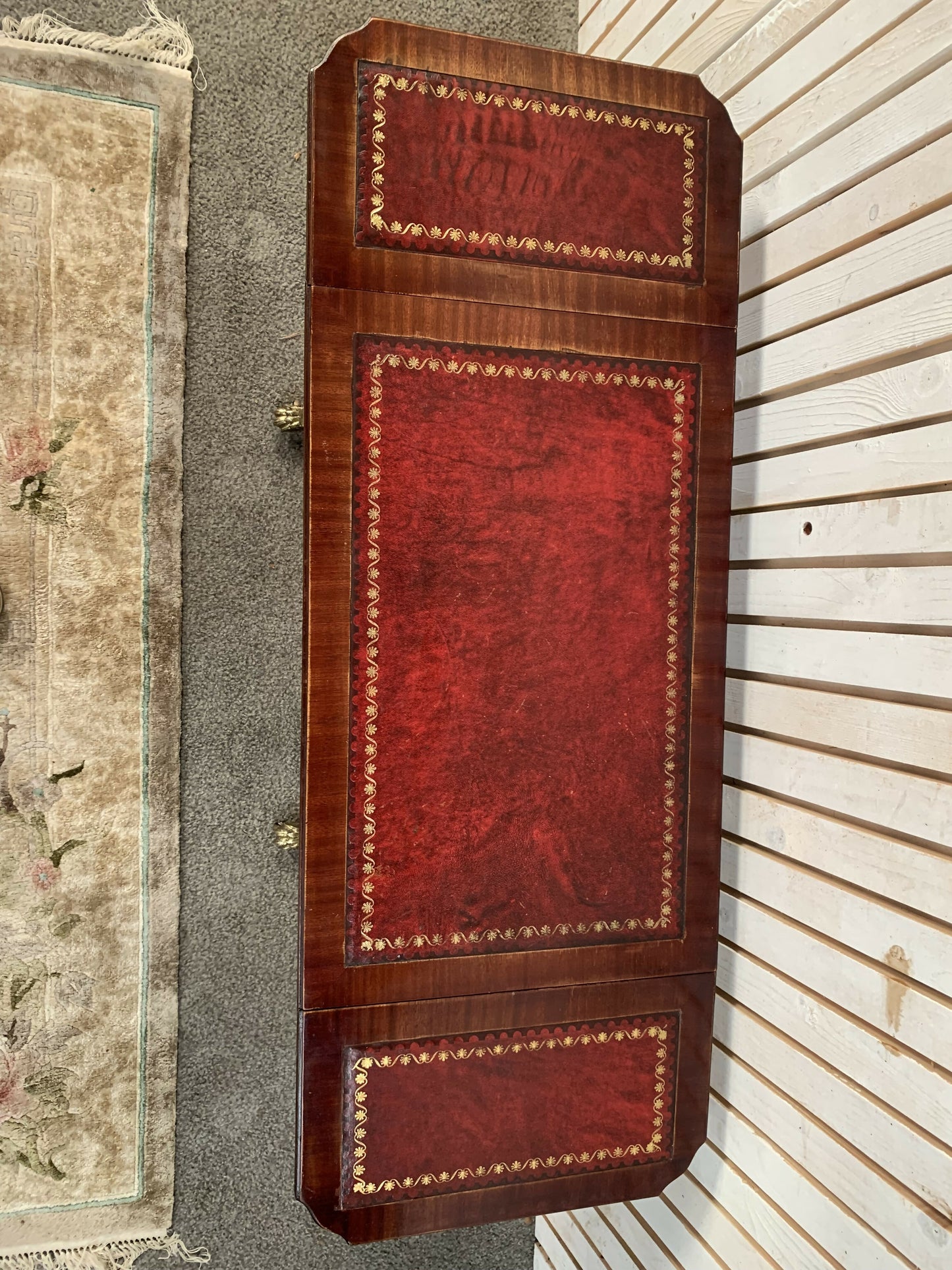 Antique drop-leaf Pembroke table with a leather top and brass claw feet.