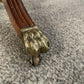 Antique drop-leaf Pembroke table with a leather top and brass claw feet.