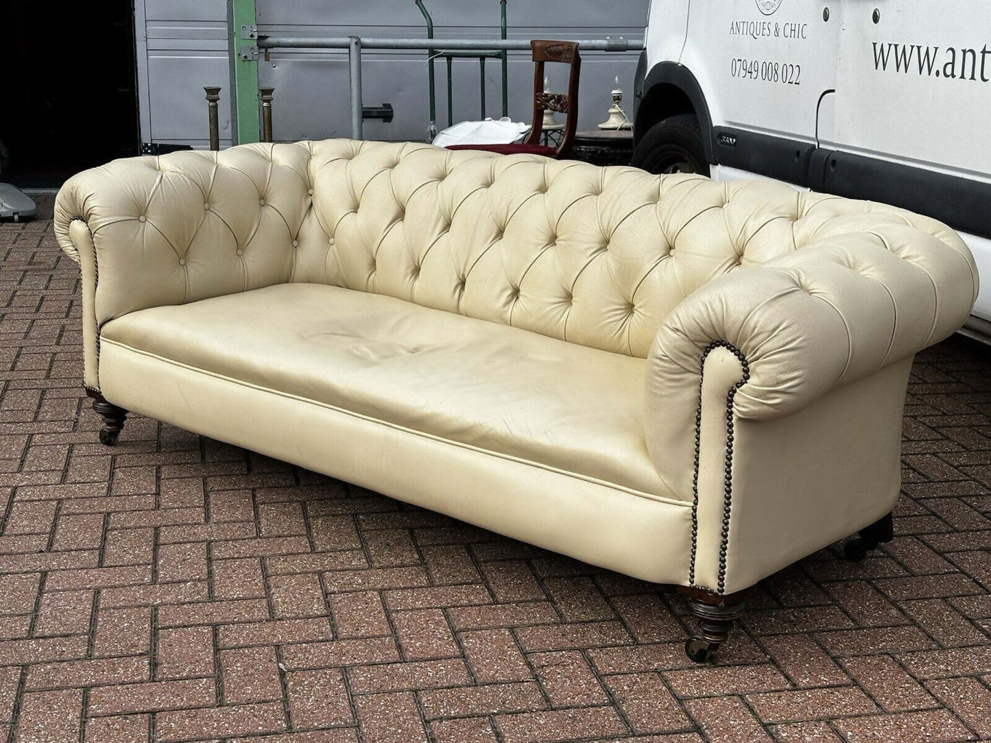 Vintage Victorian Buttoned Back Chesterfield Sofa In Leather On Brass Castors.