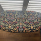 Black oval mid century modern ottoman - black paint William Morris style fabric