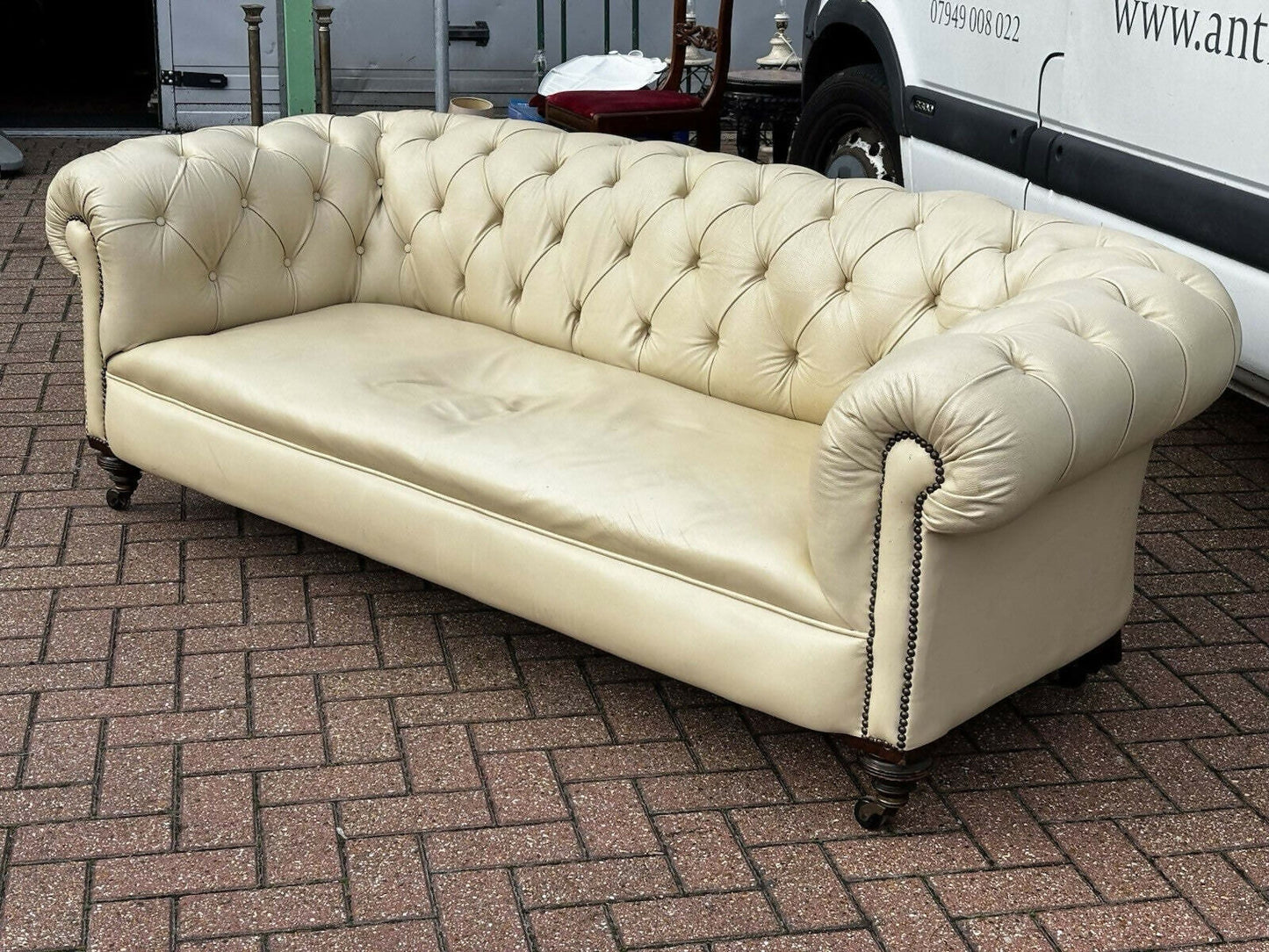 Vintage Victorian Buttoned Back Chesterfield Sofa In Leather On Brass Castors.
