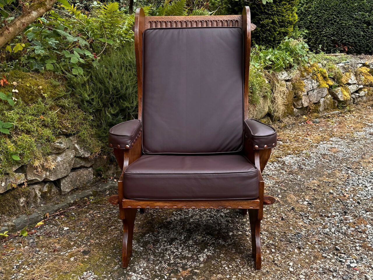A NIGEL RUPERT GRIFFITHS MONASTIC CARVED OAK LEATHER FIRESIDE CHAIR / ARMCHAIR