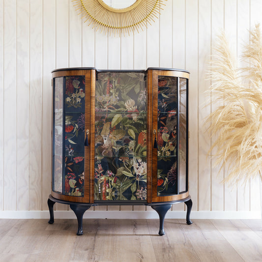 Professionally refinished Art Deco drinks cabinet, distinguished by its unique design and tropical jungle fabric. Sold, commission available.