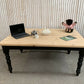 Pine dining table with a black base and a lacquered pine top.