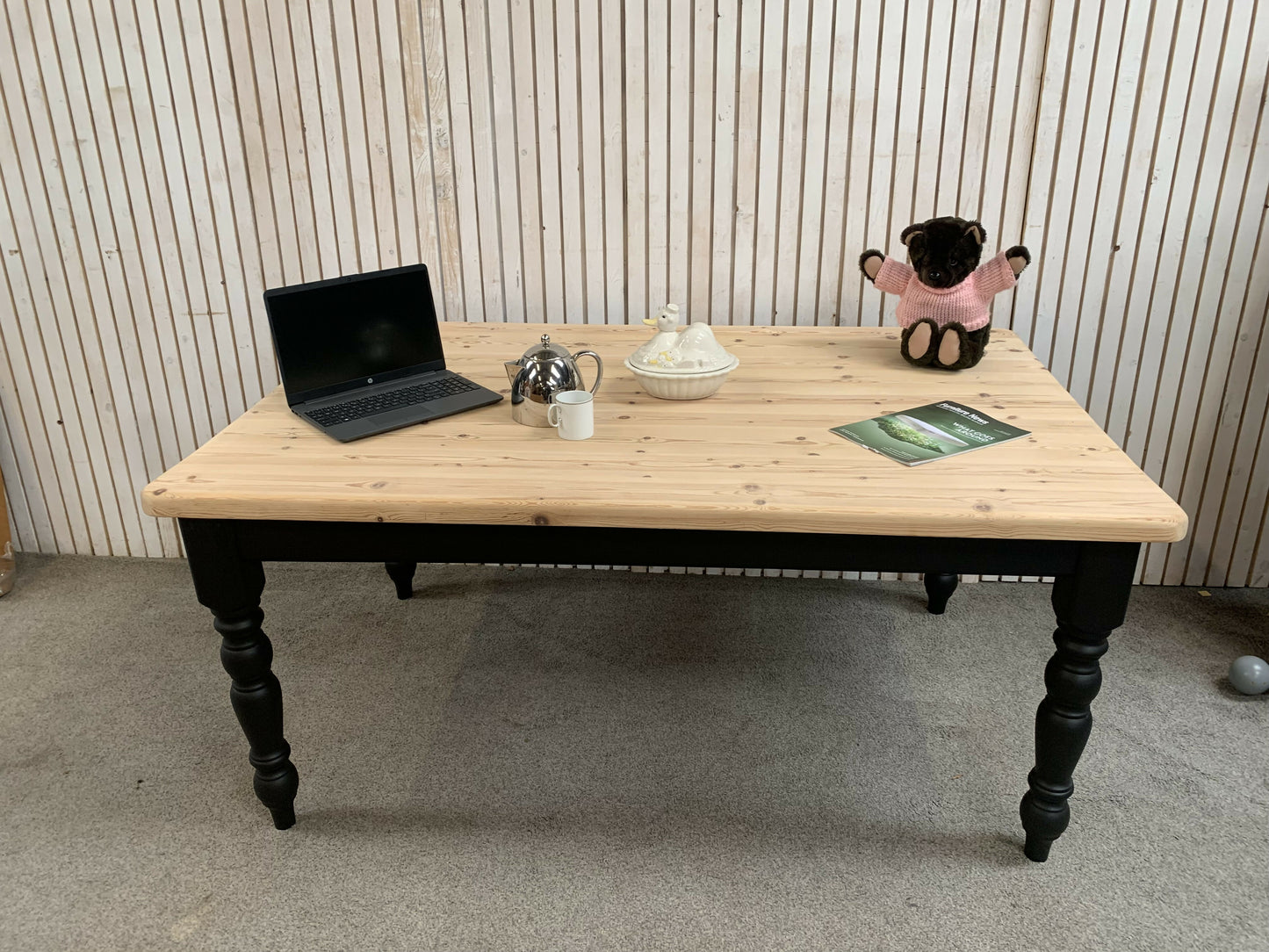 Pine dining table with a black base and a lacquered pine top.