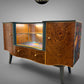 Professionally refinished vintage art deco sideboard with burr walnut, illuminated glass display and floral side panels by Black Leopard Interiors. Luxury bespoke furniture refinishing and restoration handcrafted handpainted UK