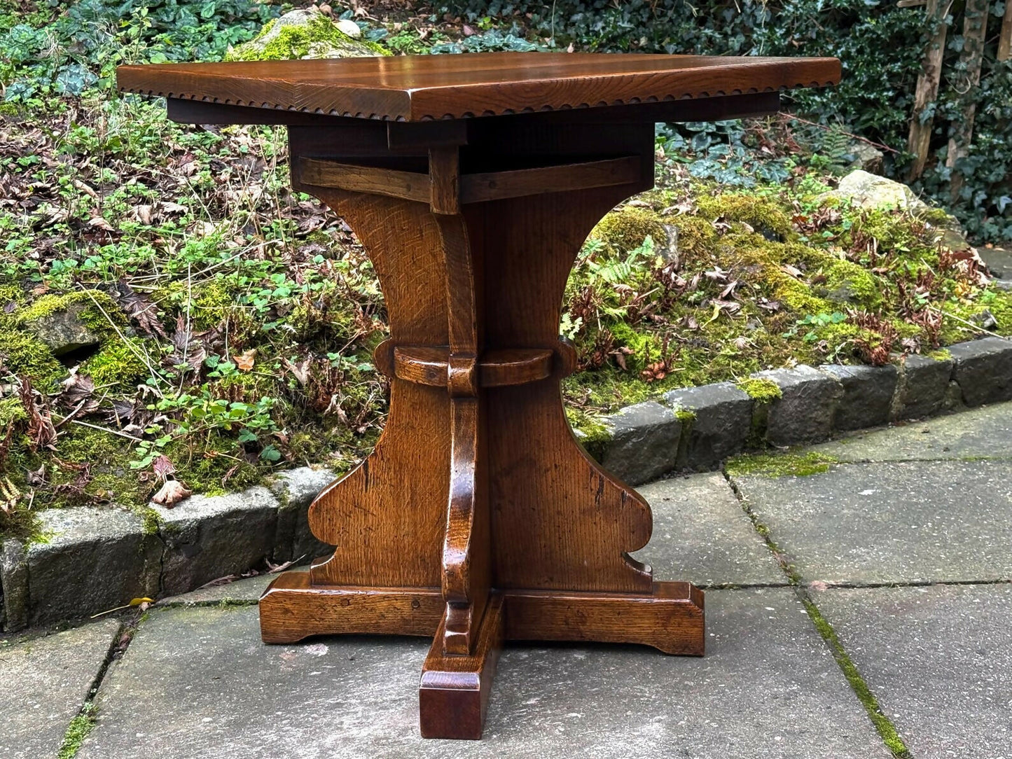 A RUPERT GRIFFITHS MONASTIC CARVED SOLID OAK LAMP TABLE / PLANT STAND