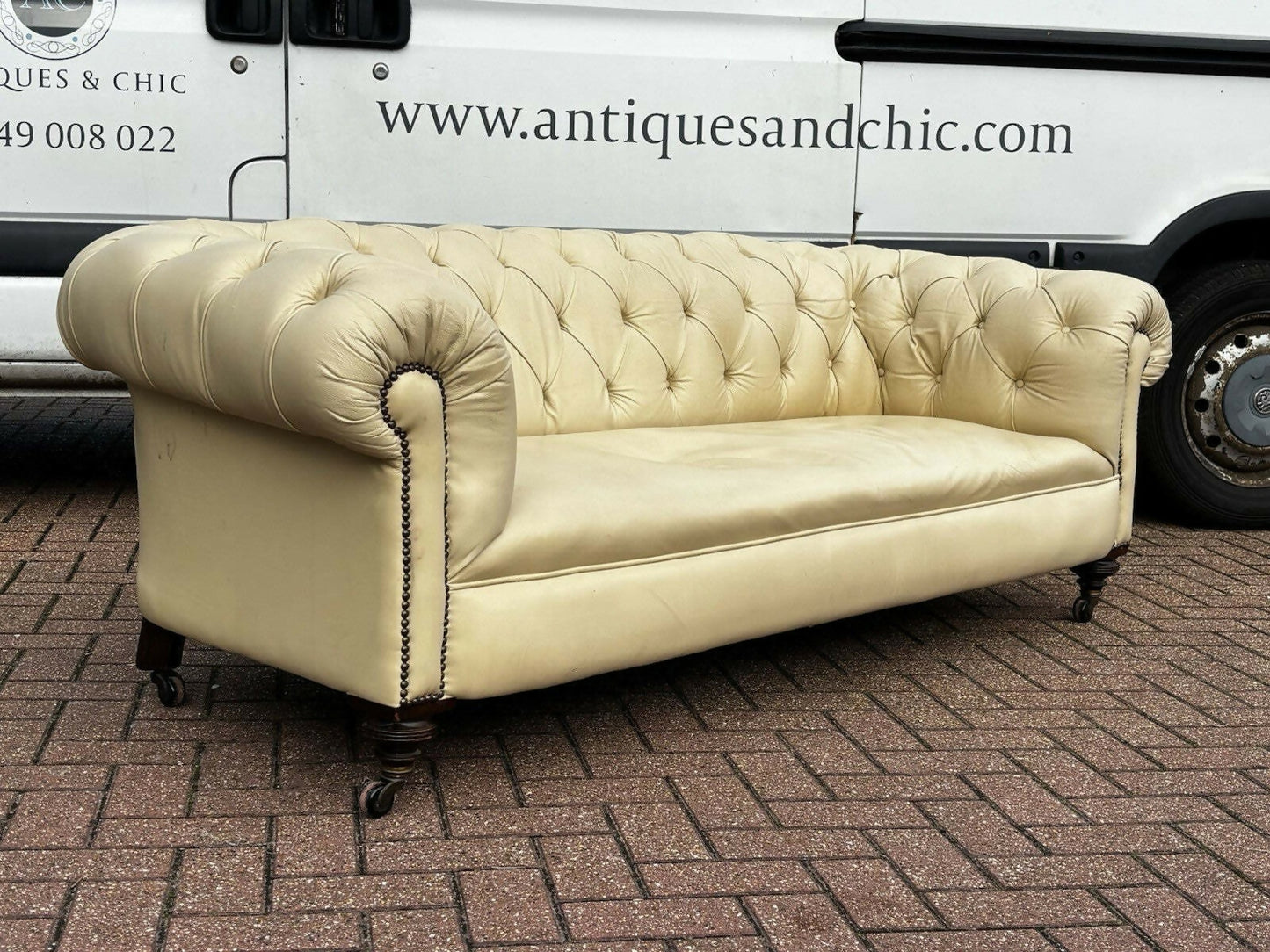 Vintage Victorian Buttoned Back Chesterfield Sofa In Leather On Brass Castors.