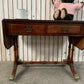 Antique drop-leaf Pembroke table with a leather top and brass claw feet.