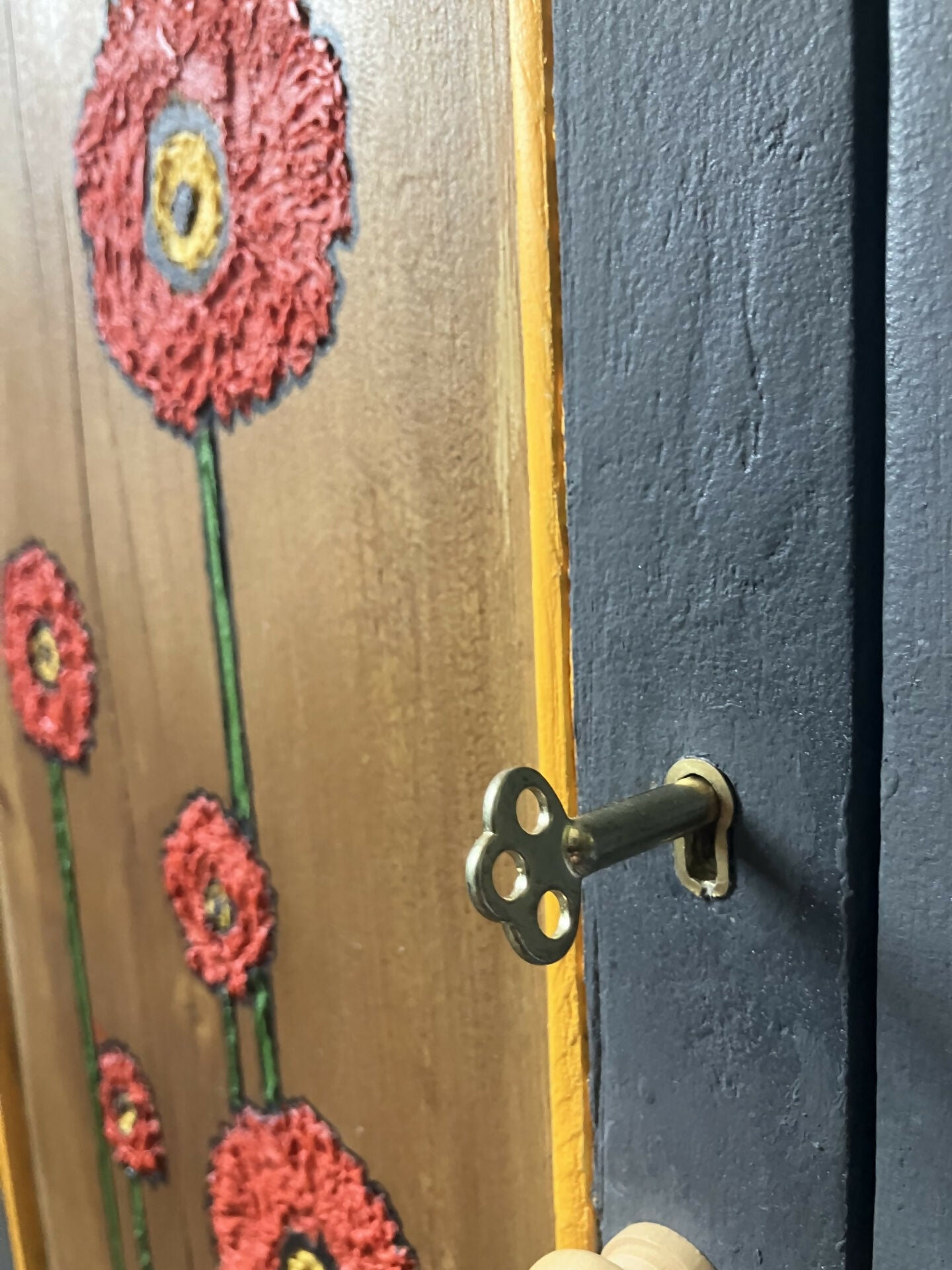 Dark grey wooden storage cabinet with hand carved flowers and linen interior