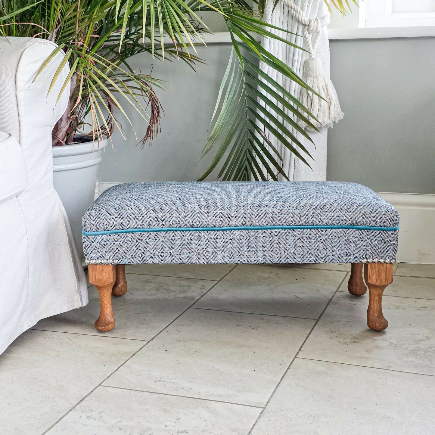 Long, Low Footstool, Restored and Reupholstered in Top Quality Woven Fabric.Teak wood feet. Newly Reupholstered.