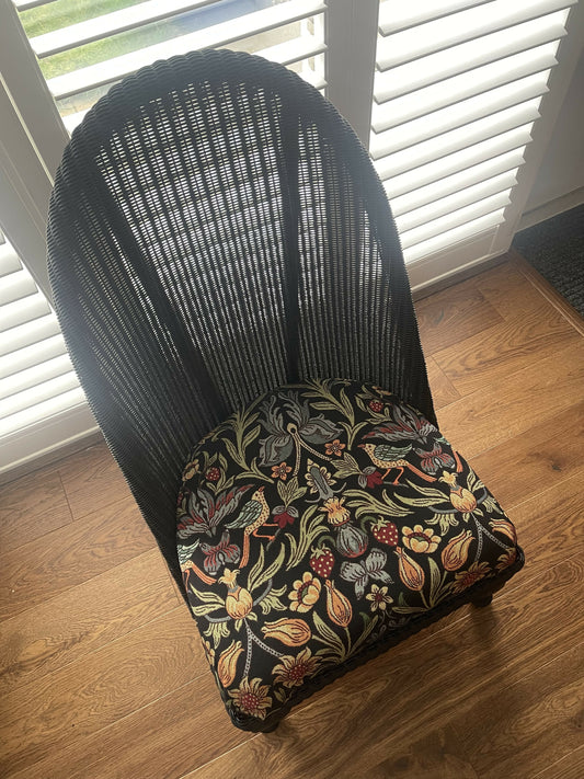 Lloyd loom low accent chair. Black satin paint and William morris style fabric