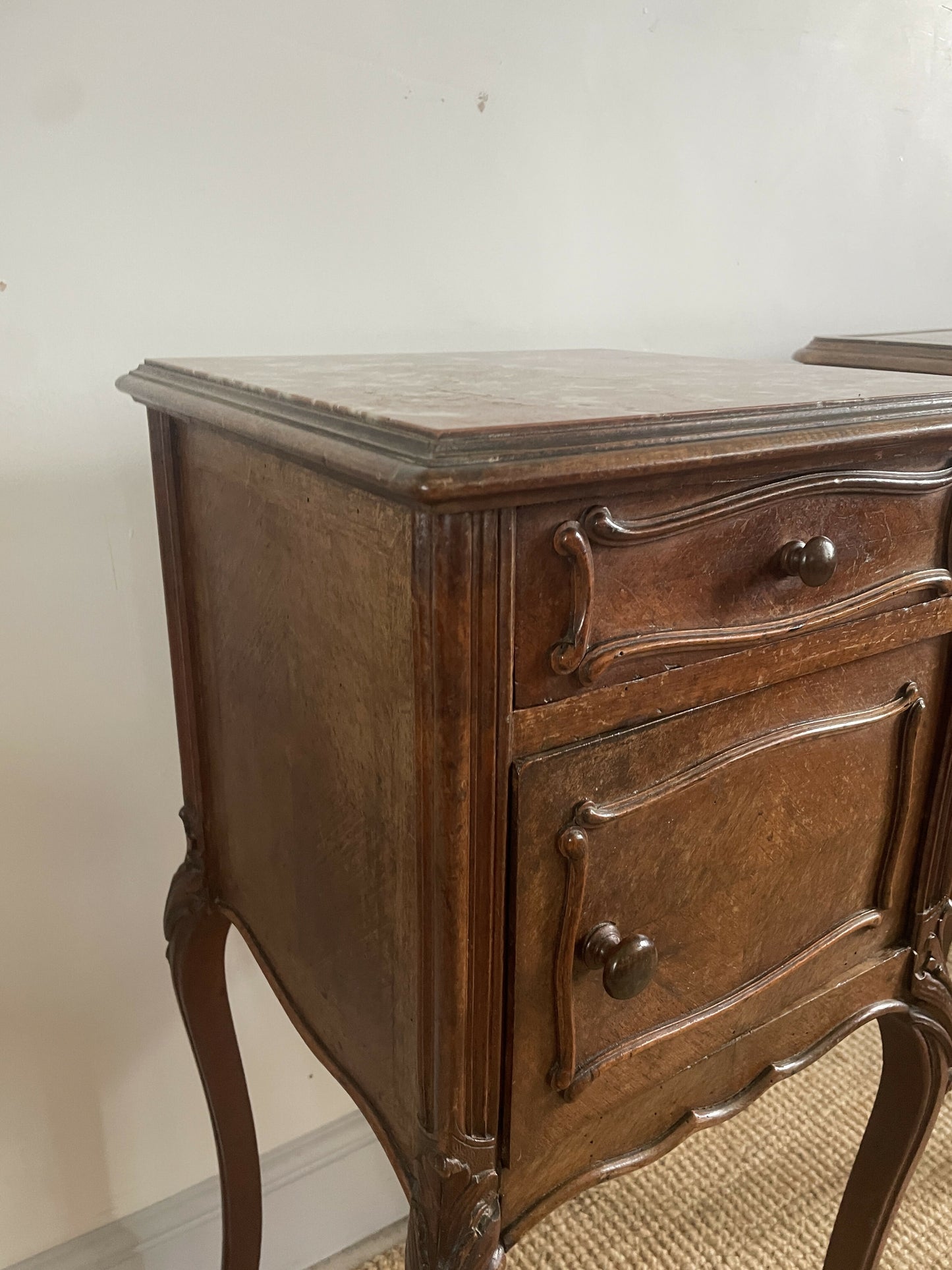 A near pair of antique French walnut and marble bedside tables