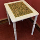 Light grey side table with hand-carved sage motif