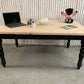 Pine dining table with a black base and a lacquered pine top.