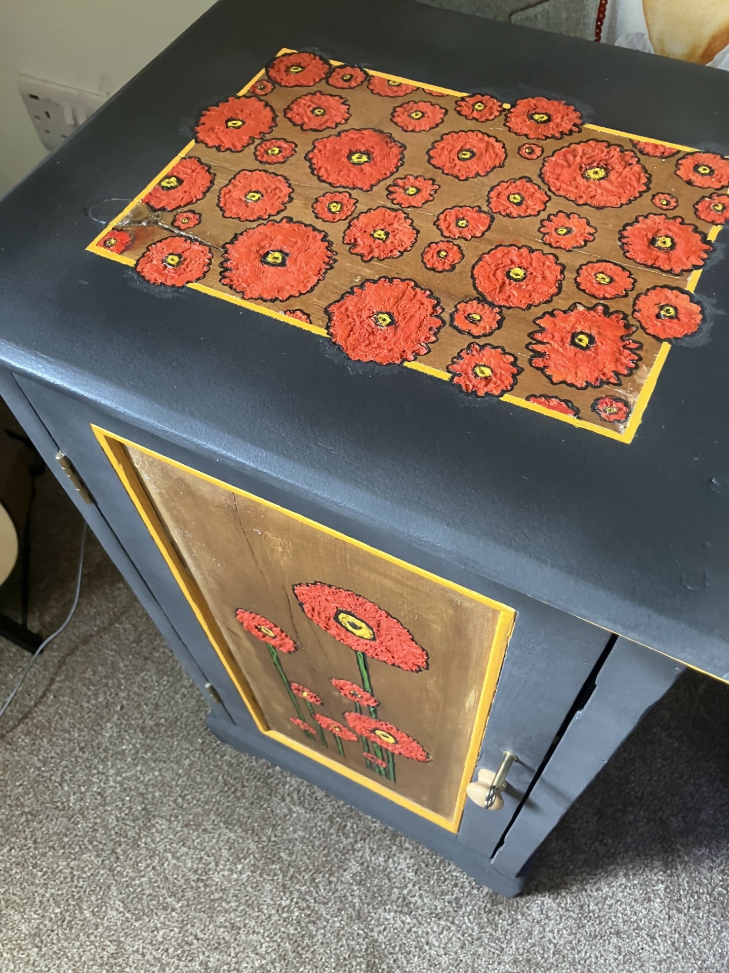 Dark grey wooden storage cabinet with hand carved flowers and linen interior