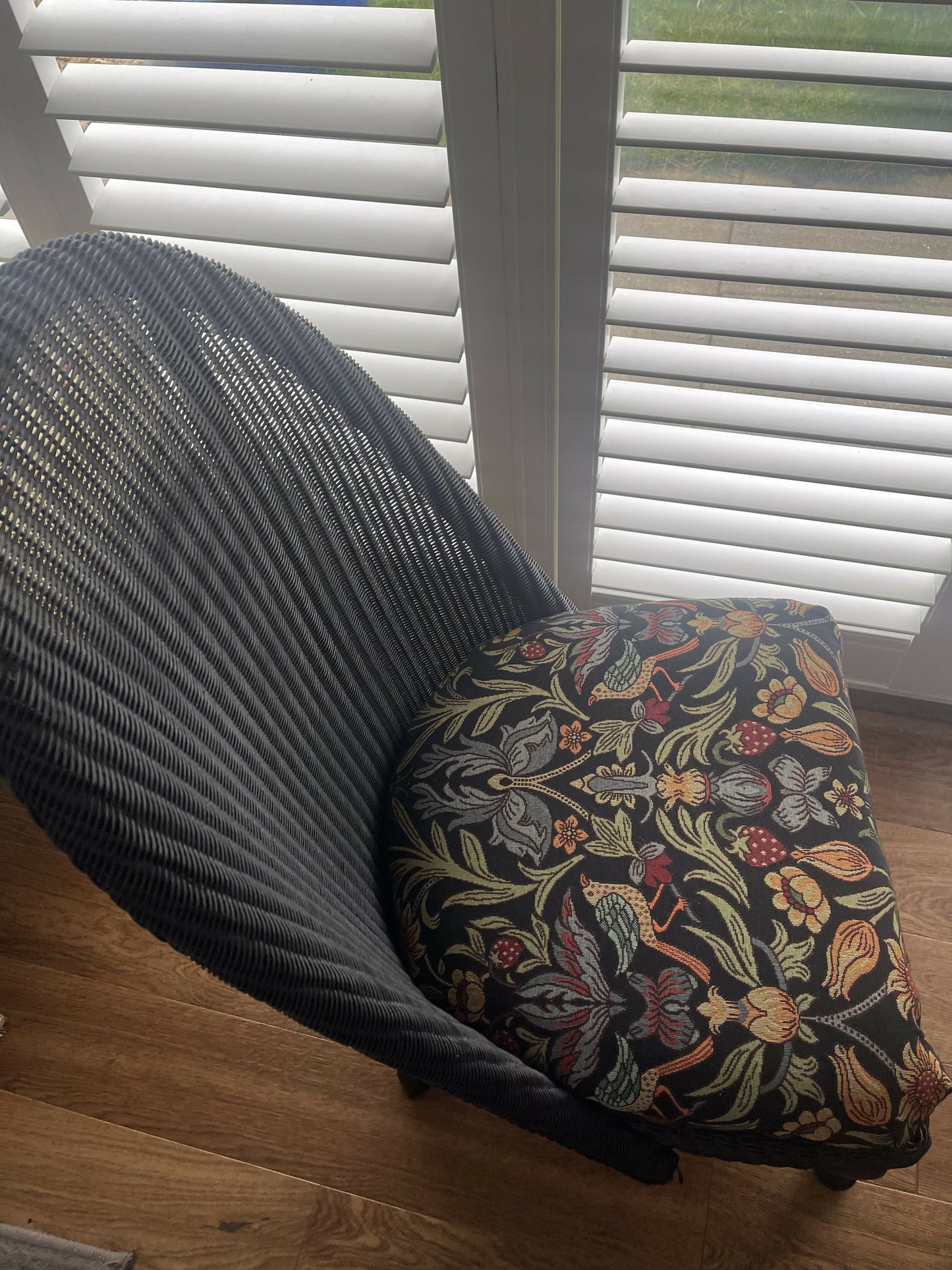 Lloyd loom low accent chair. Black satin paint and William morris style fabric