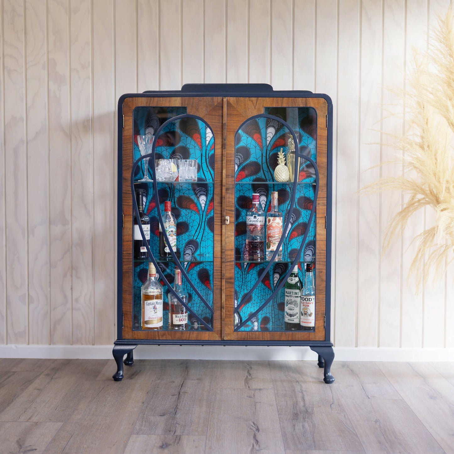 Blue Art Deco drinks cabinet, distinguished by its heart shape and decoupage featuring an African-inspired peacock feather fabric. Sold, commission available.