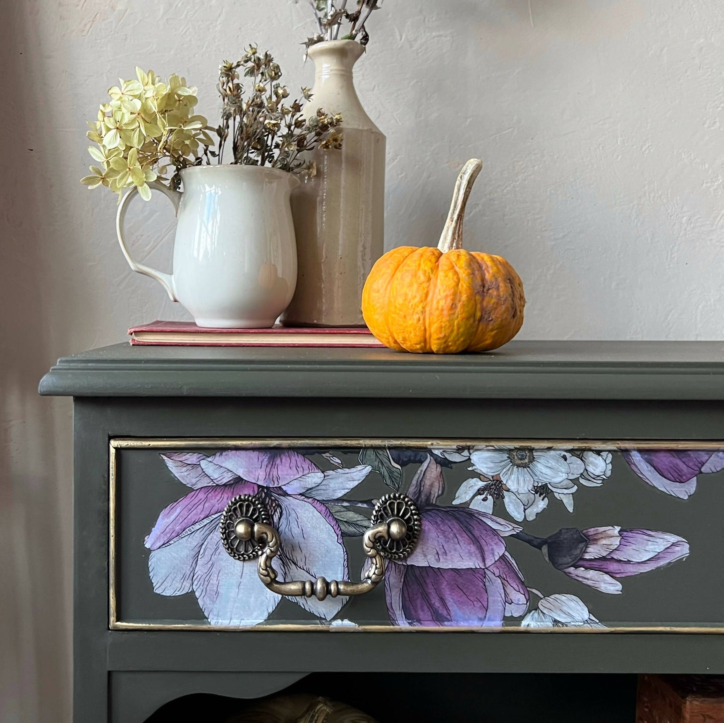 Vintage bookcase painted green with floral detail