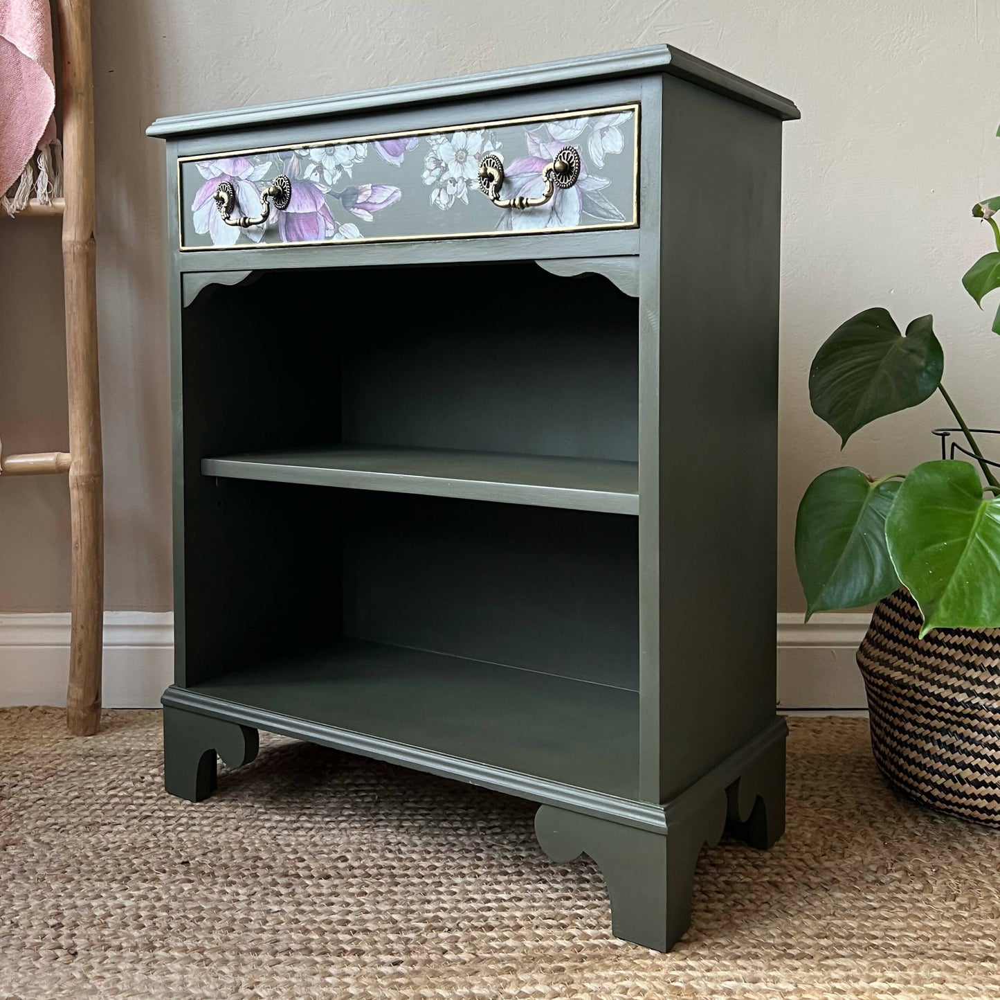 Vintage bookcase painted green with floral detail