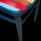 Hand painted school chair with vibrant rainbow stripe seat and gold leaf backrest. Abstract art design.